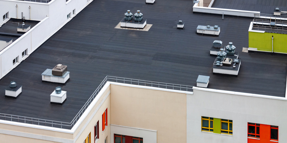 top view dark flat roof with air conditioners and hydro insulation membranes